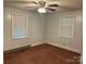 Empty bedroom featuring a ceiling fan and natural light from two windows at 5722 Oak Dr, Charlotte, NC 28216