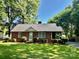 Charming brick house with mature landscaping, providing a welcoming curb appeal at 5722 Oak Dr, Charlotte, NC 28216