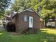 Charming brick home with well-maintained lawn and mature trees providing shade at 5722 Oak Dr, Charlotte, NC 28216