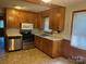 Cozy kitchen with tile floors, wood cabinets, and stainless steel appliances at 5722 Oak Dr, Charlotte, NC 28216