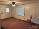 Inviting living room featuring carpet, ceiling fan, and natural light from the windows at 5722 Oak Dr, Charlotte, NC 28216