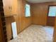 A room featuring wood paneling, built-in cabinet, and tile floors at 5722 Oak Dr, Charlotte, NC 28216