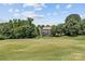 A view of a lush green backyard featuring a well-maintained golf course and a house at 615 N Oak Dr, Huntersville, NC 28078