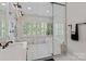 Luxurious bathroom featuring a glass-enclosed shower with double shower heads and a soaking tub under shuttered windows at 615 N Oak Dr, Huntersville, NC 28078