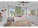 Bright bedroom featuring large windows, a ceiling fan, and light, neutral decor at 615 N Oak Dr, Huntersville, NC 28078