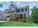Charming two-story home with blue siding, stone accents, a covered porch, and manicured landscaping at 615 N Oak Dr, Huntersville, NC 28078