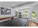 Large game room with a pool table, shuffleboard, and gaming station with natural light from large windows at 615 N Oak Dr, Huntersville, NC 28078