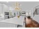 Open concept kitchen with island seating flows to a sunlit living room and staircase at 615 N Oak Dr, Huntersville, NC 28078