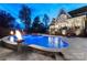 Elegant home with an outdoor pool, fire pit, and inviting patio area at dusk at 6216 North Rd, York, SC 29745