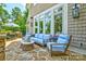 Cozy outdoor patio featuring stone floors, comfortable blue seating, and lush greenery at 6216 North Rd, York, SC 29745