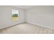 Bright bedroom with neutral carpet and window overlooking the backyard at 7008 Jerimoth Dr, Charlotte, NC 28215