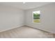 Bedroom featuring neutral carpet and a bright window overlooking the backyard at 7008 Jerimoth Dr, Charlotte, NC 28215