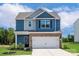 Two-story home with blue siding, brick facade, and a two-car garage exudes modern curb appeal at 7008 Jerimoth Dr, Charlotte, NC 28215