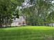 Traditional-style home featuring a lush green lawn and mature trees, providing shade and enhancing its curb appeal at 7137 Sythe Ct, Charlotte, NC 28226