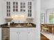Stylish bar area with wine storage, sink, and elegant cabinetry at 7912 Baltusrol Ln, Charlotte, NC 28210