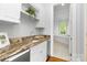 Convenient wet bar with wine cooler, granite countertop, and access to the primary bathroom at 7912 Baltusrol Ln, Charlotte, NC 28210