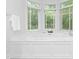 Soaking tub nestled beneath bay windows, creating a bright and inviting spa-like atmosphere at 7912 Baltusrol Ln, Charlotte, NC 28210
