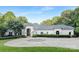 Elegant white home with a circular driveway and lush landscaping at 7912 Baltusrol Ln, Charlotte, NC 28210