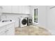 Bright laundry room featuring modern appliances, white cabinets, and tile floors at 7912 Baltusrol Ln, Charlotte, NC 28210