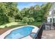 Beautiful backyard with a refreshing swimming pool and mature trees at 7912 Baltusrol Ln, Charlotte, NC 28210