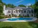 Stunning rear exterior view of the home with a swimming pool, spa, and spacious backyard at 7912 Baltusrol Ln, Charlotte, NC 28210
