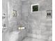 Walk-in shower featuring gray tile walls, bench, shower head and built-in shelf storage at 7912 Baltusrol Ln, Charlotte, NC 28210