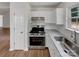 Modern kitchen featuring stainless steel appliances, white cabinets, granite countertops, and wood-look flooring at 8219 Pozzi Rd, Charlotte, NC 28216