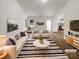 Bright, staged living room with modern furniture, neutral tones, and wood-look flooring, offering a welcoming atmosphere at 8219 Pozzi Rd, Charlotte, NC 28216