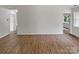 Open living area featuring wood-look floors, neutral walls, and multiple doorways and windows for ample light at 8219 Pozzi Rd, Charlotte, NC 28216