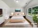 Staged main bedroom features a plush bed, modern decor, ample natural light, and stylish accents at 8219 Pozzi Rd, Charlotte, NC 28216