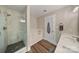 Modern bathroom features glass shower, soaking tub, and wood-look flooring at 8310 Brickle Ln, Huntersville, NC 28078