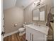 Cozy bathroom featuring a toilet, a wood-look floor, and a vanity with a square-style sink at 8310 Brickle Ln, Huntersville, NC 28078