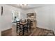 Dining room featuring shiplap walls, wood floors, modern lighting and a view to the kitchen at 8310 Brickle Ln, Huntersville, NC 28078