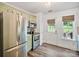 Updated kitchen with stainless steel appliances, herringbone backsplash and a view to an exterior door at 8310 Brickle Ln, Huntersville, NC 28078