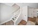 Bright staircase features white railing and wood-look flooring and door at 8310 Brickle Ln, Huntersville, NC 28078