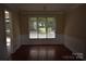 Bright dining room featuring hardwood floors, wainscoting, and a large window overlooking the backyard at 9228 Old Barnette Pl, Huntersville, NC 28078