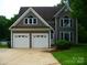Charming home featuring a two-car garage, well-maintained landscaping, and architectural details at 9228 Old Barnette Pl, Huntersville, NC 28078