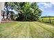 Expansive backyard features a lush lawn and wood fence along with a wood deck and seating area at 9808 Steed Ct, Charlotte, NC 28269