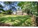 Large manicured backyard with mature trees, fenced border, and a wood deck with furniture at 9808 Steed Ct, Charlotte, NC 28269