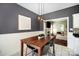 Cozy dining area featuring a rustic wood table, modern lighting fixtures, and an open view to the living room at 9808 Steed Ct, Charlotte, NC 28269