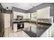 Well-lit kitchen featuring stainless steel appliances, decorative backsplash, granite countertops, and white cabinetry at 9808 Steed Ct, Charlotte, NC 28269