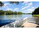 Stunning view of the lake from a wooden deck with white railings and a clear blue sky at 9808 Steed Ct, Charlotte, NC 28269