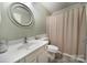 Well-lit bathroom with a vanity, round mirror, toilet, and shower area at 1003 Cranberry Cir, Fort Mill, SC 29715
