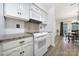 Well-lit kitchen showcasing stylish backsplash, white cabinets, and modern cooking appliances at 1003 Cranberry Cir, Fort Mill, SC 29715