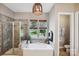 Bathroom with tub, stand-alone shower, and wooden light fixture at 1009 Hercules Dr, Indian Trail, NC 28079