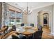 Elegant dining room with a round table, chandelier, and large windows dressed with patterned curtains at 1009 Hercules Dr, Indian Trail, NC 28079