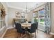 Well-lit dining room with wood floors, modern chandelier, and large windows offering views of the landscaped yard at 1009 Hercules Dr, Indian Trail, NC 28079