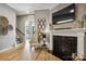 Cozy living room showcasing a fireplace, mantel with decor, and hardwood floors at 1009 Hercules Dr, Indian Trail, NC 28079