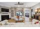 Open concept living room features wood floors, fireplace, TV, sofas, and natural light shining in from the rear patio doors at 1009 Hercules Dr, Indian Trail, NC 28079