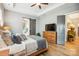 Main bedroom featuring a tray ceiling, natural light, hardwood floors, and ensuite bathroom at 1009 Hercules Dr, Indian Trail, NC 28079